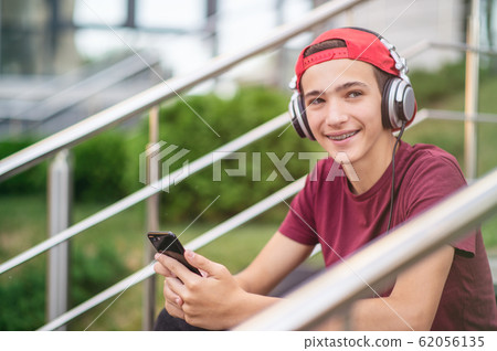 Young man listen to the music in a big earphones, Young man listen to the music in a big earphones, 62056135