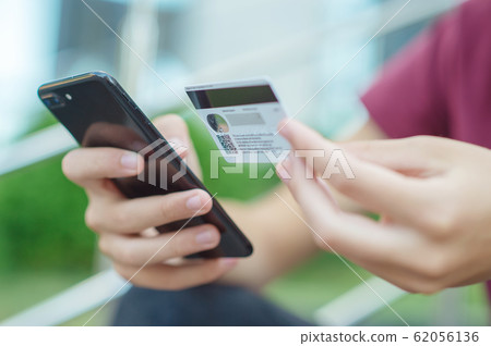 Close-up human hands with mobile phone and credit 62056136