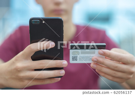 Close-up human hands with mobile phone and credit Close-up human hands with mobile phone and credit 62056137