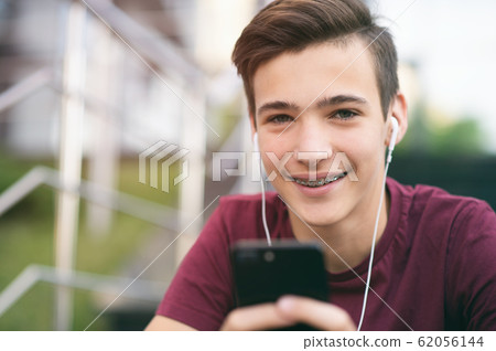 Close-up portrait of a smiling young man with a Close-up portrait of a smiling young man with a 62056144