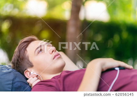 Close-up portrait of a sad young man lying on the Close-up portrait of a sad young man lying on the 62056145