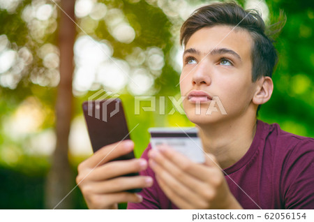 Teenage boy with a credit card and phone, Teenage boy with a credit card and phone, 62056154