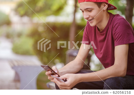 Teenage boy with a credit card and phone makes Teenage boy with a credit card and phone makes 62056158