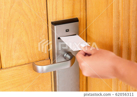 Woman hand with keycard in the electronic lock. Woman hand with keycard in the electronic lock. 62056311