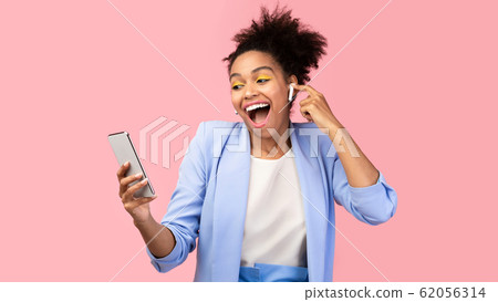 Portrait of smiling afro woman enjoying her music 62056314