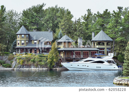 Building in a grassy area on the coast of a lake 62058228