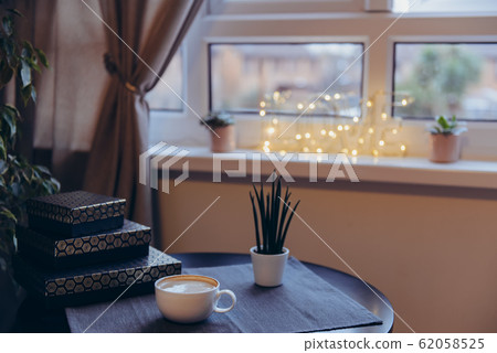Cup with coffee on black table near window with Cup with coffee on black table near window with 62058525