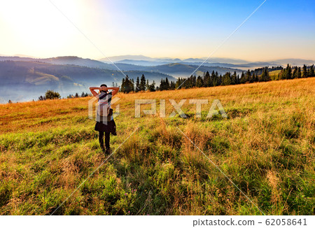 Young woman inhales the aroma of wild herbs Young woman inhales the aroma of wild herbs 62058641