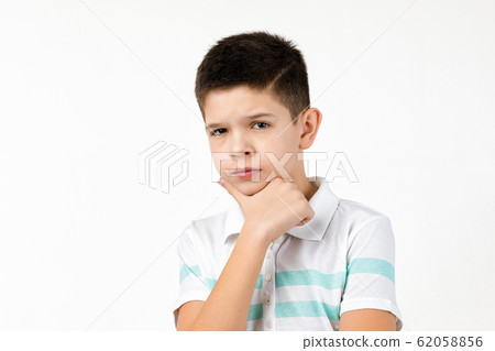 Cute little child boy in striped t-shirt thinks about something Cute little child boy in striped t-shirt thinks about something 62058856