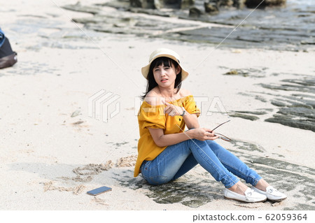Woman relaxing on sandy beach 62059364