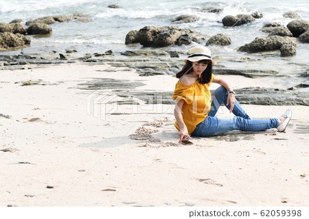 Woman relaxing on sandy beach Woman relaxing on sandy beach 62059398