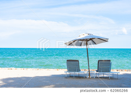 Beautiful umbrella and chair around beach sea ocean with blue sky for travel Beautiful umbrella and chair around beach sea ocean with blue sky for travel 62060266