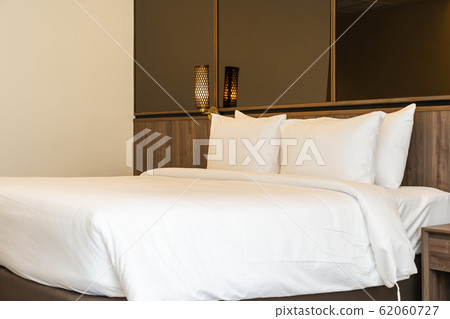 Pillow and blanket on bed with light lamp decoration interior Pillow and blanket on bed with light lamp decoration interior 62060727