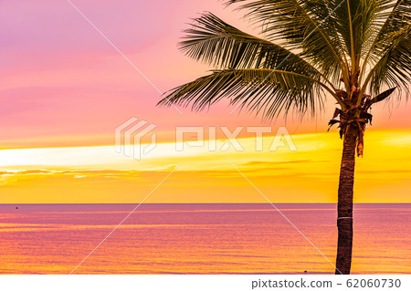 Beautiful sea ocean beach with palm tree at sunrise time for holiday Beautiful sea ocean beach with palm tree at sunrise time for holiday 62060730