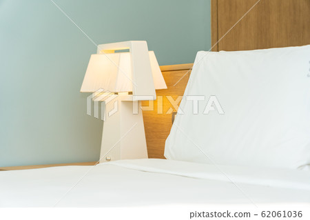 Pillow and blanket on bed with light lamp decoration interior 62061036