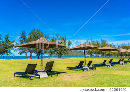 Beautiful outdoor landscape of sea and beach with umbrella and chair around there Beautiful outdoor landscape of sea and beach with umbrella and chair around there 62061091