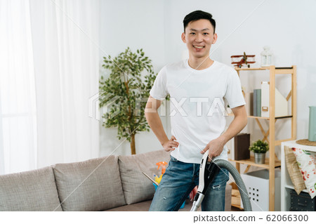 guy face camera smiling holding vacuum cleaner guy face camera smiling holding vacuum cleaner 62066300