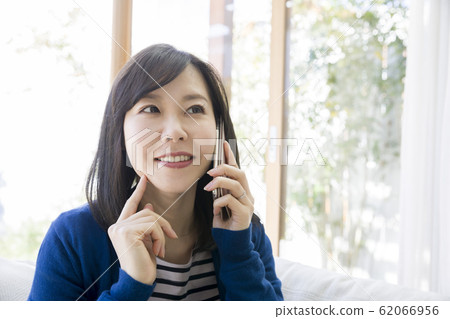 生活方式：一個年輕的女人在講智能手機 62066956