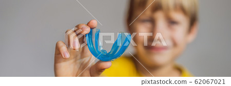 Six-year old boy shows myofunctional trainer. Helps equalize the growing teeth and correct bite 62067021