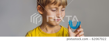 Six-year old boy shows myofunctional trainer. Helps equalize the growing teeth and correct bite Six-year old boy shows myofunctional trainer. Helps equalize the growing teeth and correct bite 62067022