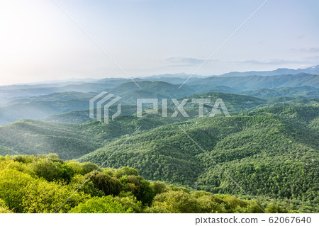Layers of mountains in the haze during sunset. 62067640