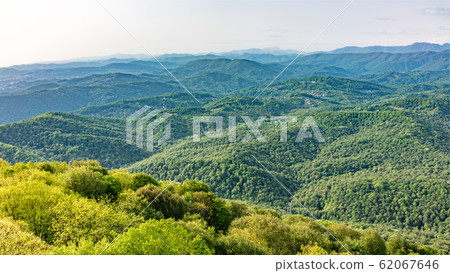 Layers of mountains in the haze during sunset. 62067646