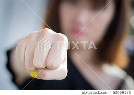 angry aggressive woman punching her fist; angry 62069158
