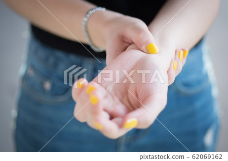 sick woman with trigger finger pain; portrait of 62069162
