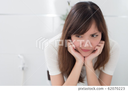 upset woman in toilet by diarrhea, constipation, 62070223