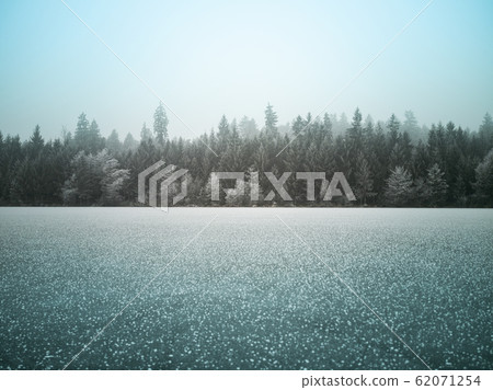 Frozen lake landscape with forest in winter - Frozen lake landscape with forest in winter - 62071254