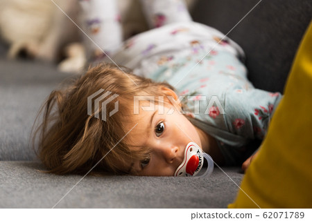 Cute 2 year old Baby girl on a bed on her belly Cute 2 year old Baby girl on a bed on her belly 62071789