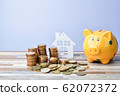 Close up of Wooden home, piggy bank and stack of 62072372