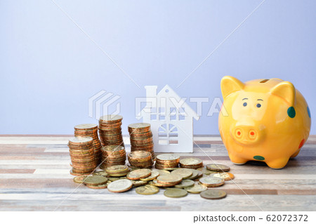 Close up of Wooden home, piggy bank and stack of 62072372