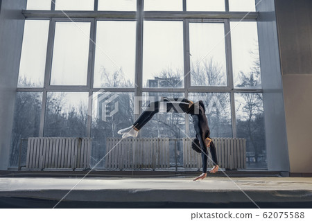 Little male gymnast training in gym, flexible and active 62075588