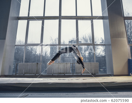 Little male gymnast training in gym, flexible and active 62075590