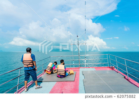 Tourists relaxing on boat deck and use smartphone on hot sunny day. Tourists relaxing on boat deck and use smartphone on hot sunny day. 62075882