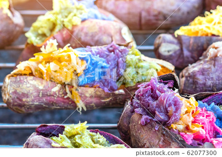 Colorful of many Thai traditional desserts stuffed in grilled yams on stove for sale on street food. Colorful of many Thai traditional desserts stuffed in grilled yams on stove for sale on street food. 62077300