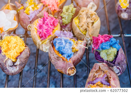 Colorful of many Thai traditional desserts stuffed in grilled yams on stove for sale on street food. Colorful of many Thai traditional desserts stuffed in grilled yams on stove for sale on street food. 62077302