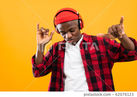 closeup portrait attractive smiling black american guy listening to music on headphones and dancing 62078123