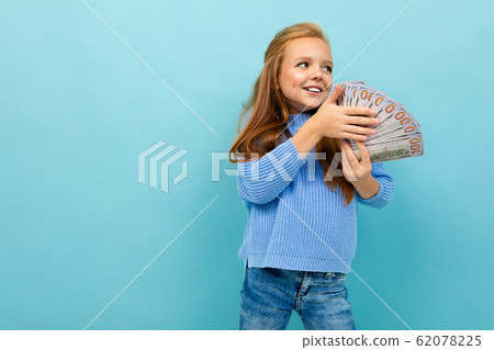 Portrait of little caucasian girl with long brow hair in blue hoody holds a lot of money isolated on 62078225
