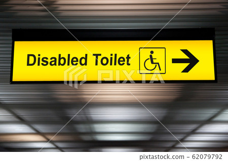 sign with arrow point to disabled toilet at the airport for passenger with impaired body. universal design for elderly or the disabled in public place concept. 62079792