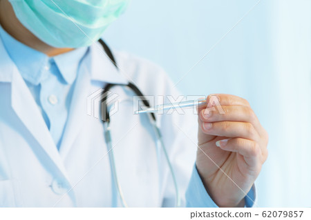 Coronavirus stop infection. young female doctor wearing mask with thermometer and stethoscope 62079857