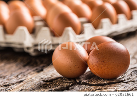 Chicken eggs in carton box on rustic wooden table 62081661