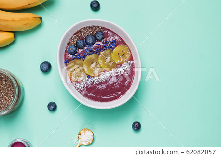 Acai berry smoothie bowl topped with seeds, flowers and blackberries 62082057