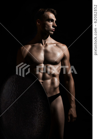 Young warrior with shield isolated on black. Young warrior with shield isolated on black. 62082852