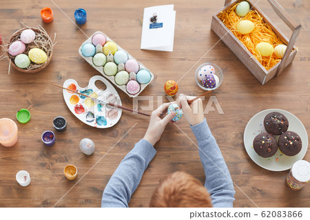 Boy decorating eggs for Easter 62083866
