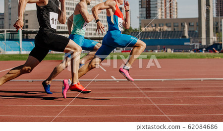 men sprinters run on track 62084686