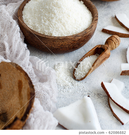 Coconut flour in a bowl with a spoon close up 62086882