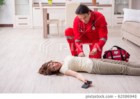 Young male paramedic visiting young woman 62086948