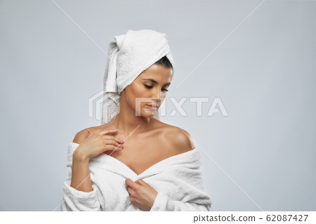 Woman in bathrobe touching naked shoulder. Woman in bathrobe touching naked shoulder. 62087427